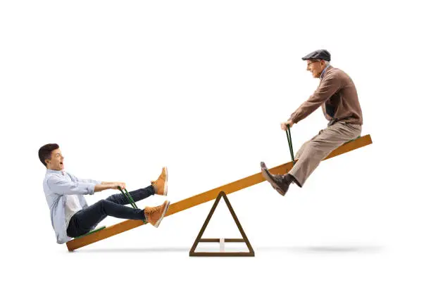 Teenage boy with his grandfather on a seesaw isolated on white background