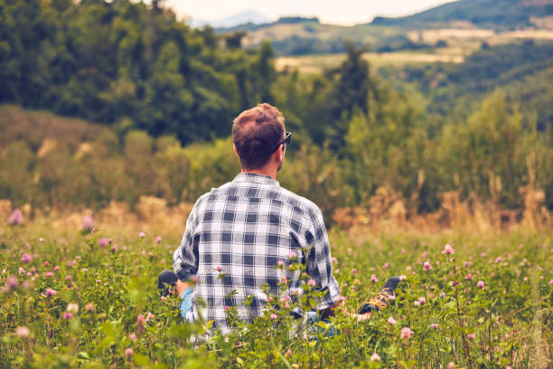 istock Man taking a break in nature and looking at the distant landscape. 1081952518