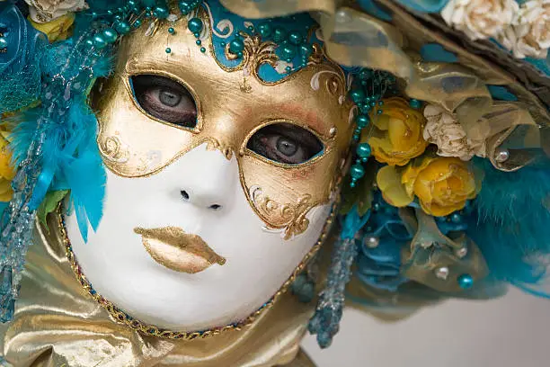 Portrait of white female mask in beautiful creative costume at carnival in Venice, Italy.