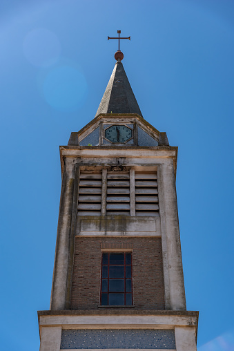Dome or Bell tower of an old church with a clock in a day with a blue clean sky