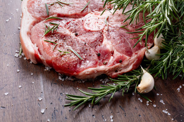 istock Raw pork with rosemary , salt and pepper. 1081956552