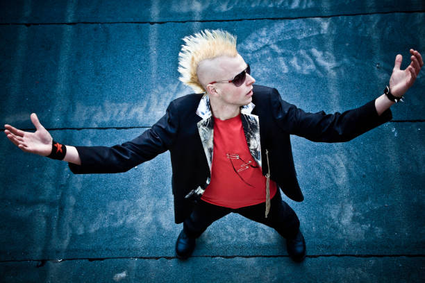 Stylish musician gesturing rock and roll symbol with hands, expressing his passion for music and rebellious attitude
