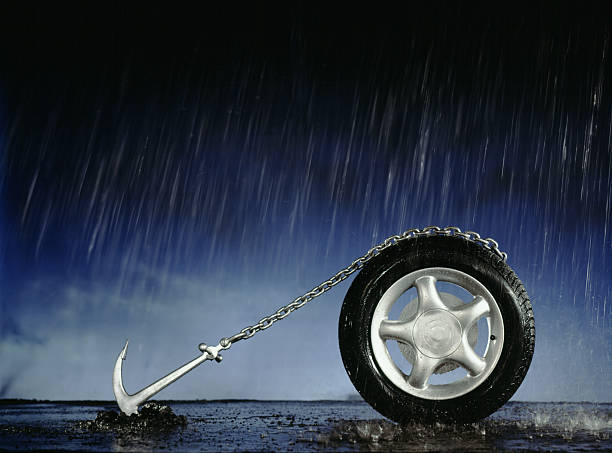 Car Wheel Anchored to Ground in Pouring Rain  anchor vessel part stock pictures, royalty-free photos & images