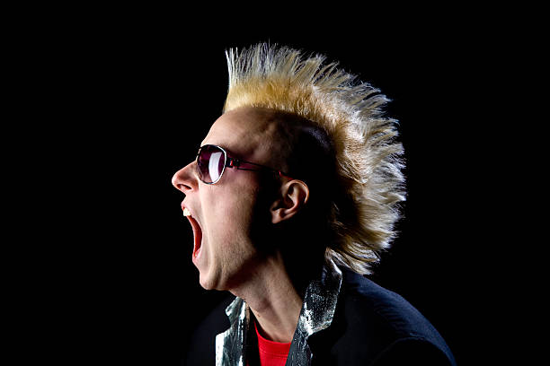 jeune homme avec coiffure punk coiffure yelling sur fond noir - blond hair photos et images de collection