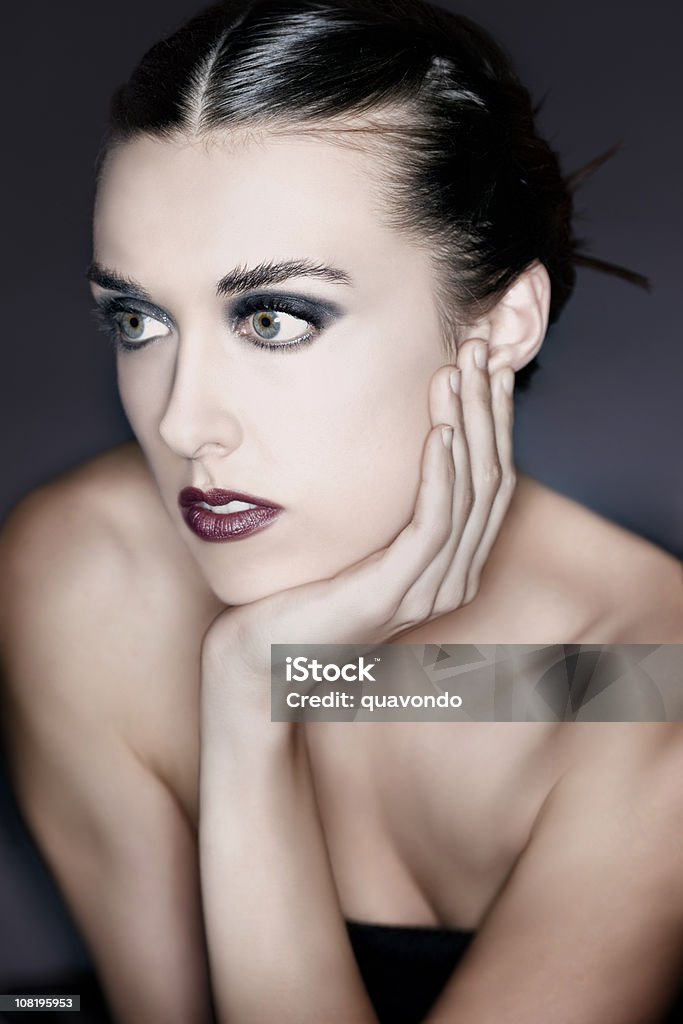 Beautiful Brunette Young Woman Portrait in Makeup and Updo Beauty portrait of young woman with updo, makeup includes blue eyeshadow and lipstick. CLICK FOR SIMILAR IMAGES AND LIGHTBOX WITH MORE BEAUTIFUL WOMEN. http://www.quavondo.com/thumbs/IStockLightboxWomen.jpg 20-29 Years Stock Photo