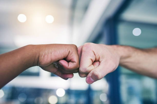 la determinazione fa tutto il possibile - women standing fist success foto e immagini stock