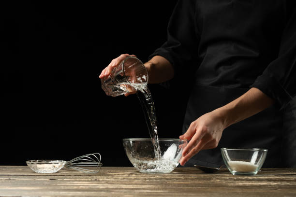 istock Baker preparing yeast dough, on a dark background. Bakery concept and dough preparation 1081960224