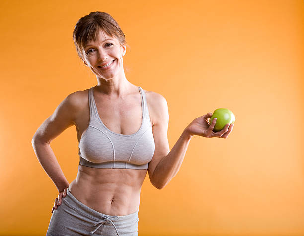 fitness femme d'âge mûr manger équilibré - fruit bodies photos et images de collection
