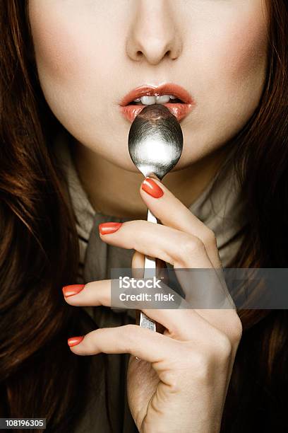 Frau Holding Spoon In Mouth Stockfoto und mehr Bilder von Braunes Haar - Braunes Haar, Nur Erwachsene, Schmecken