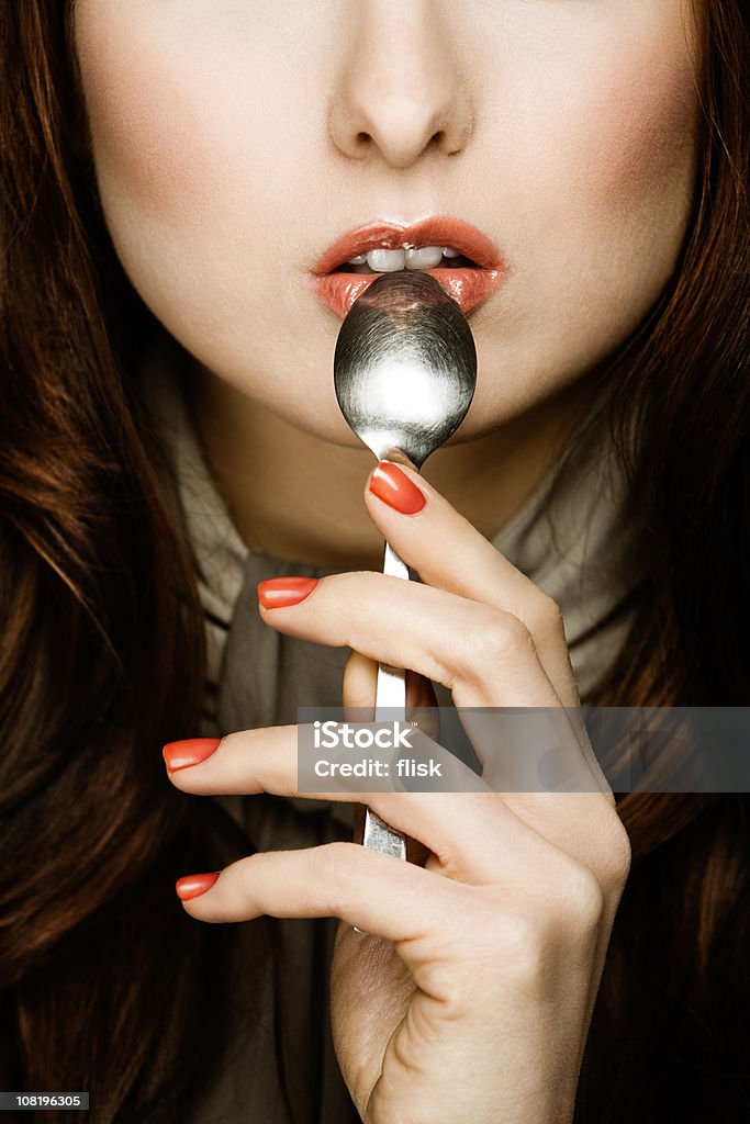 Mujer sosteniendo una cuchara para la boca - Foto de stock de Cabello castaño libre de derechos