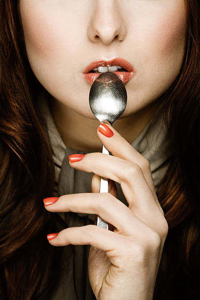 mujer sosteniendo una cuchara para la boca - spoon tasting women sex symbol fotografías e imágenes de stock