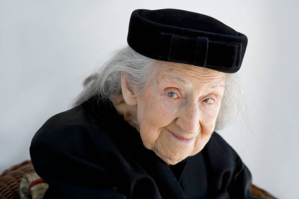 Retrato de mulher sênior usando chapéu de veludo e jaqueta preta - foto de acervo