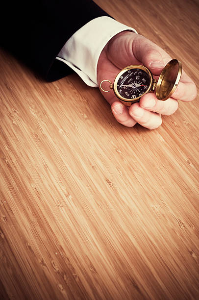 istock Businessman's Hand on Desk Holding Compass 108196420