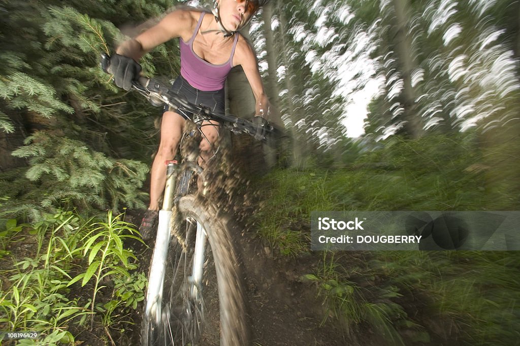 Motion shot of hembra mounatin de motorista - Foto de stock de Lodo libre de derechos