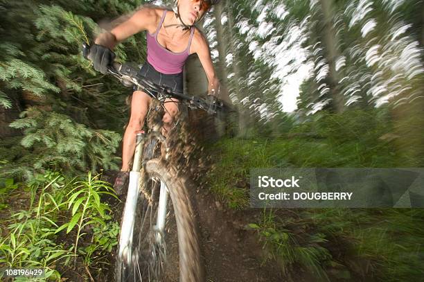 Motion Shot Of Hembra Mounatin De Motorista Foto de stock y más banco de imágenes de Lodo - Lodo, Una sola mujer, Accesorio de cabeza