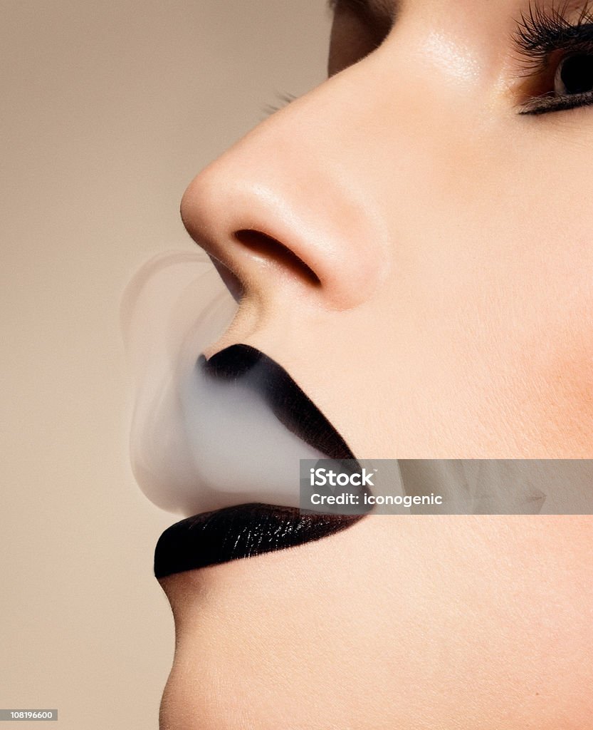 Mulher usando Batom preto e soprando fumaça - Foto de stock de Fumar royalty-free