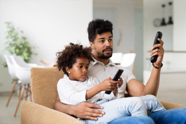 istock Father and daughter sitting on couch at home 1081966204