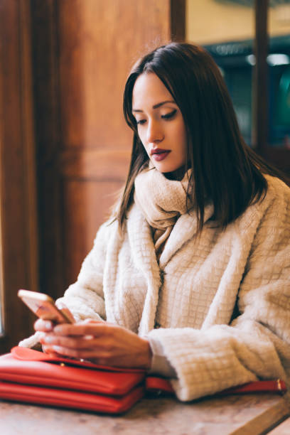 istock Woman using smartphone at coffee shop 1081966666