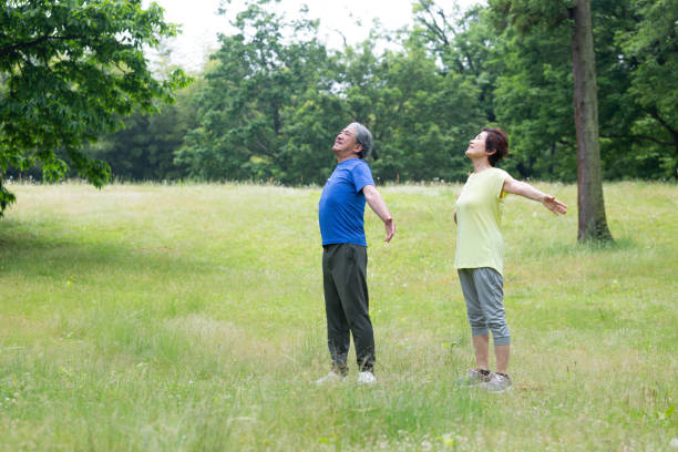 คู่อาวุโสที่จะหายใจลึก ๆ - forest bathing ภาพสต็อก ภาพถ่ายและรูปภาพปลอดค่าลิขสิทธิ์