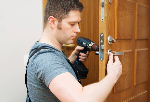 istock Young handyman in uniform changing door lock. 1081974578