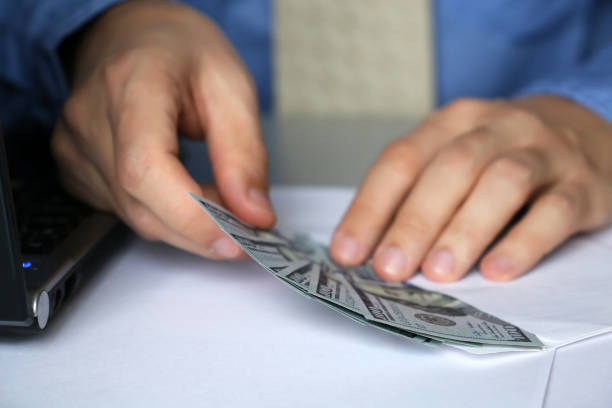 istock Man in office pulls money out of the envelope 1081976716