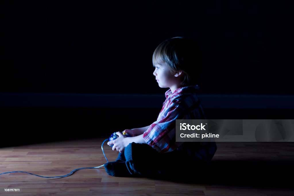 Boy plays video games in a dark room  Video Game Stock Photo