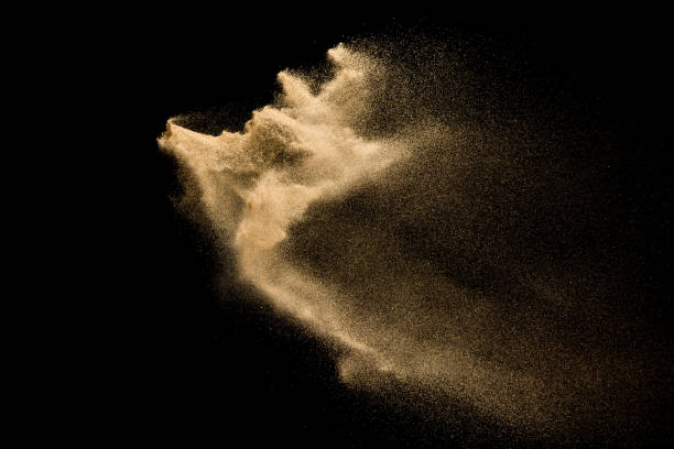 istock Golden sand explosion isolated on black background. Abstract sand cloud. 1081978982