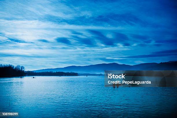 Silhouette Di Persone In Canoa Sul Lago Durante Lalba - Fotografie stock e altre immagini di Acqua