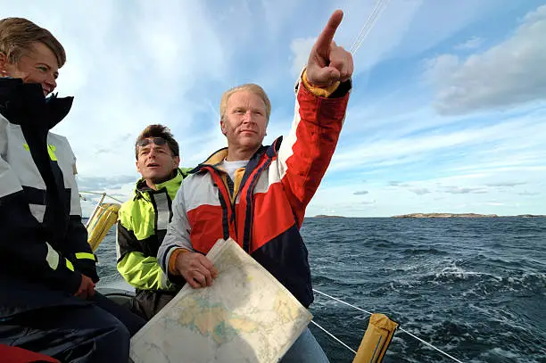 Photo of Sailor with a chart in his hand pointing forward