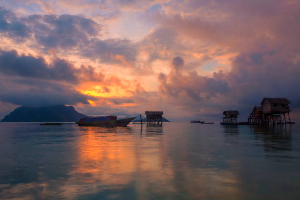 A cloudy sunrise at the sea gypsy village in Maiga Mabul Sipadan island, Semporna, Sabah, Malaysia. stock photo