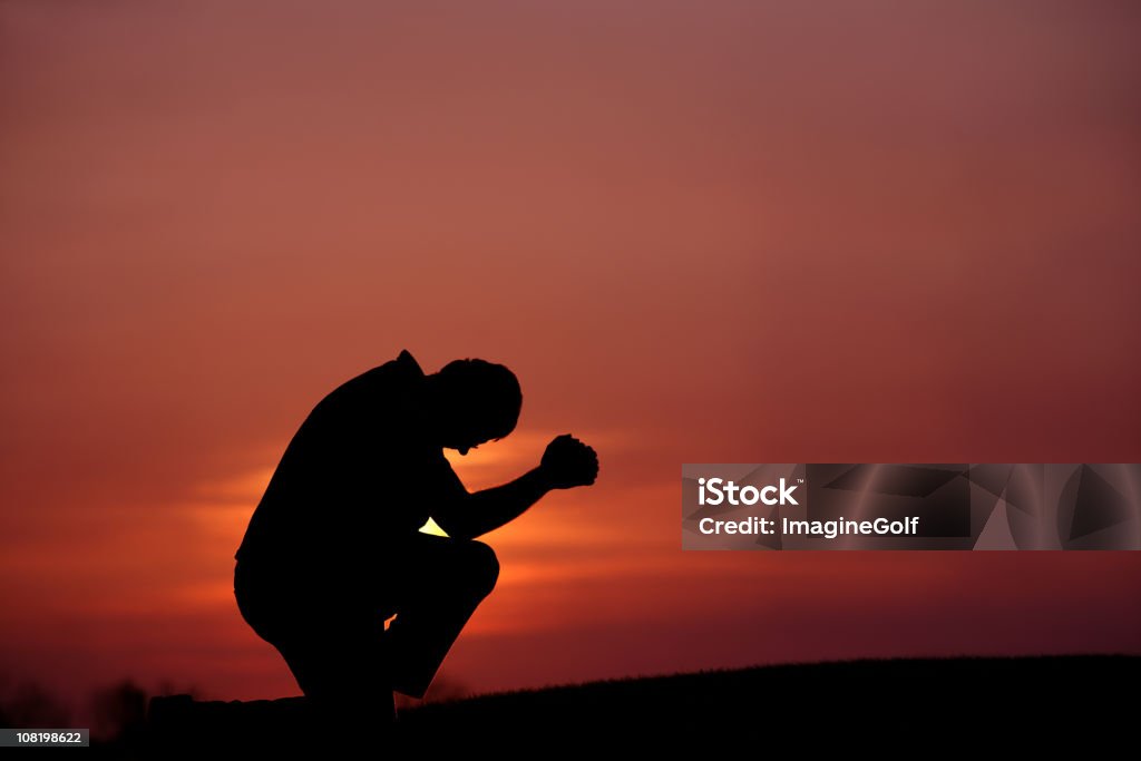 Silhouette d'un homme prier au crépuscule - Photo de Dieu libre de droits