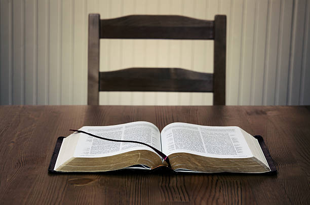 istock Bible sitting open on a table in front of an empty chair 108198683