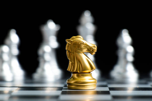 istock Gold knight chess piece face with silver team on black background (Concept for company strategy, business decision and encounter the problem) 1081988536