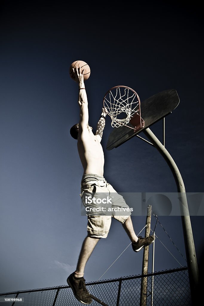 Junger Mann Dunks. Basketball-Street-Court im Netz auf - Lizenzfrei Aufnahme von unten Stock-Foto