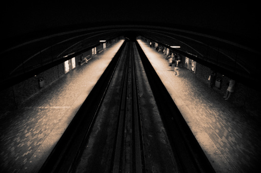 High angle view with long exposure blurred motion of commuter train on the move through Wandsworth station.