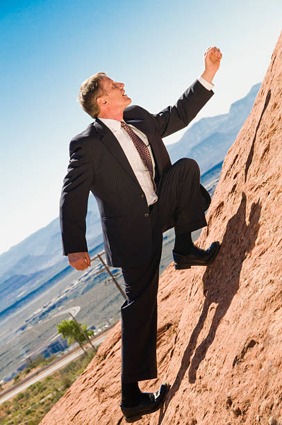 business man climbing to the top stock photo