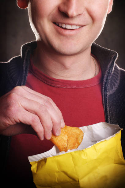 Close-up of Smiling Man Eating Potato Chips stock photo