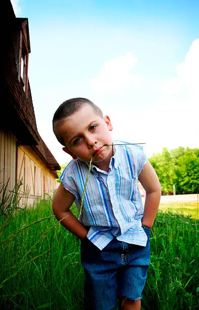 Photo of Little Boy Chewing on grass
