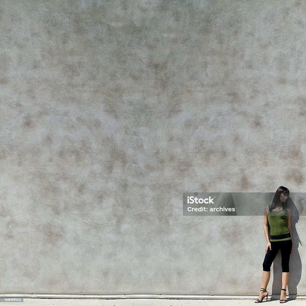 Giovane donna appoggiato contro il muro di cemento con spazio copia di - Foto stock royalty-free di Appoggiarsi