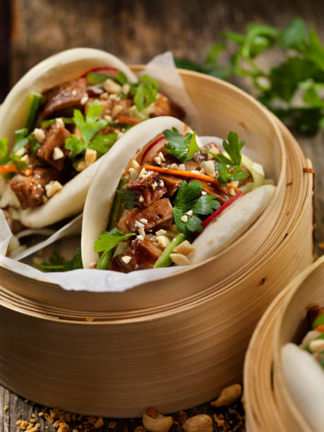 Pork Belly Bao Buns Pork Belly Bao Buns with Carrots, Coleslaw and Cilantro with a Savory Sauce hoisin sauce stock pictures, royalty-free photos & images