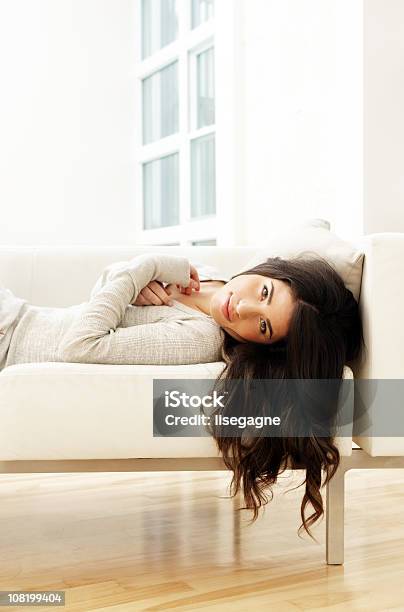 Foto de Jovem Mulher Em Um Sofá e mais fotos de stock de 20-24 Anos - 20-24 Anos, Aconchegante, Adulto