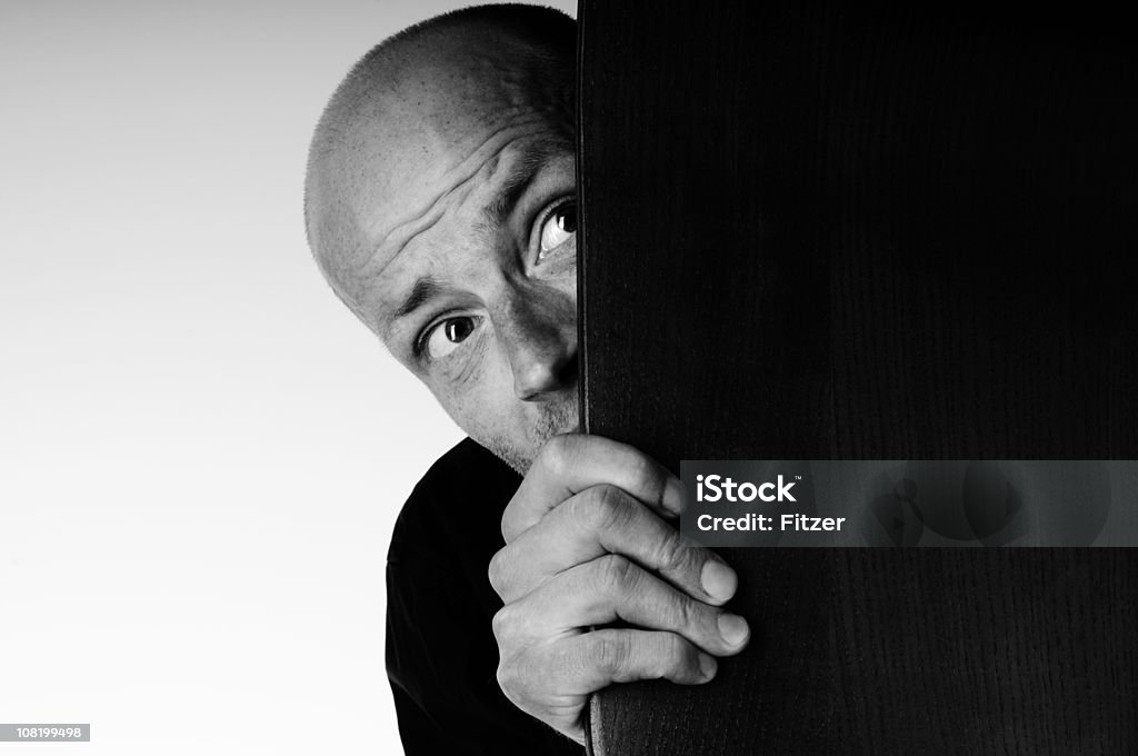 Asustada hombre mirando en esquina, blanco y negro - Foto de stock de Miedo libre de derechos
