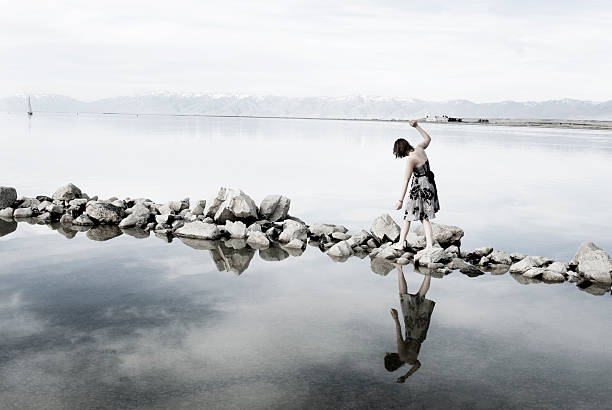 Junge Frau und balancierst auf Felsen in Lake – Foto