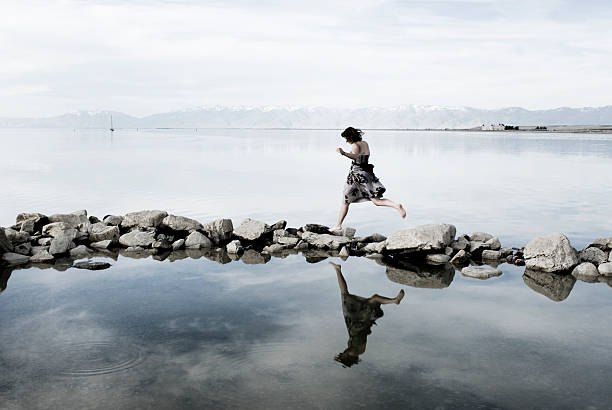 Junge Frau und balancierst auf Felsen in Lake – Foto