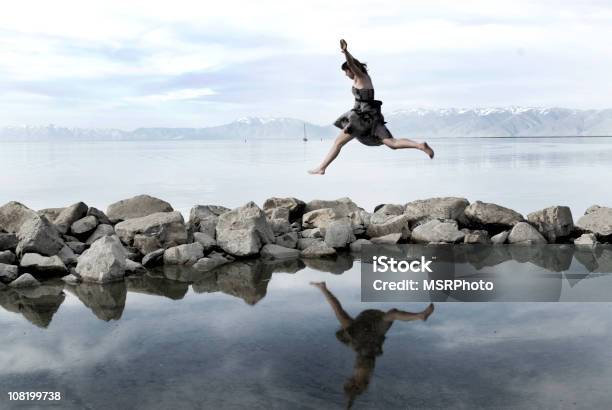 Mujer Joven Saltar Al Lago Rocks En Foto de stock y más banco de imágenes de 20-24 años - 20-24 años, Adulto, Adulto joven