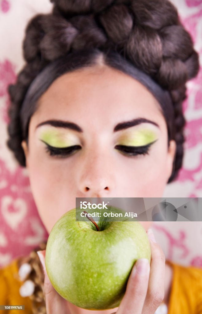 Young Woman Wearing Green Make-Up Eating Apple  Adolescence Stock Photo