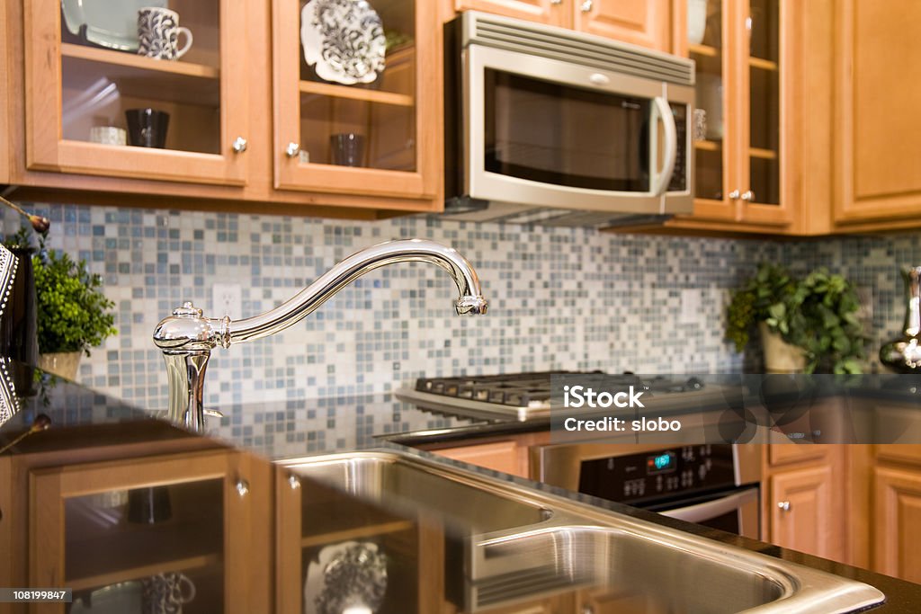 Der Wasserhahn einer modernen Küche mit Fliesen glänzenden Glasfliesen montiert ist. - Lizenzfrei Kachel Stock-Foto