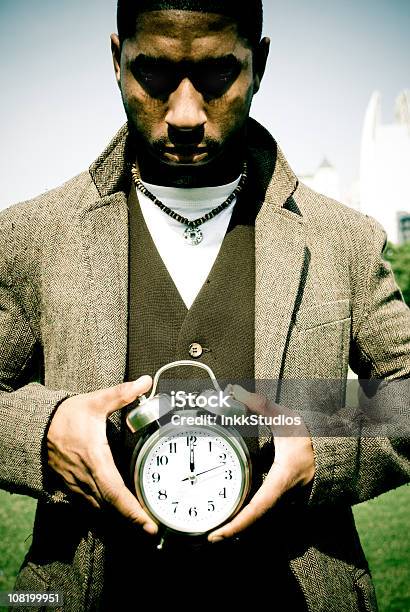 Hombre Que Agarra Un Reloj Despertador Foto de stock y más banco de imágenes de Reloj - Reloj, 20 a 29 años, Abrigo