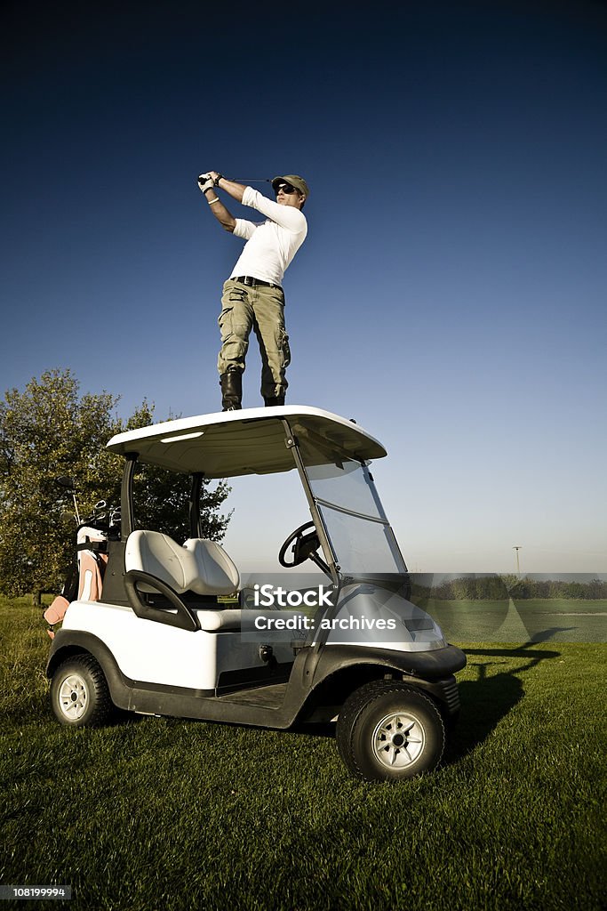 Junger Mann Golf auf dem Dach des Golf Cart - Lizenzfrei Baum Stock-Foto