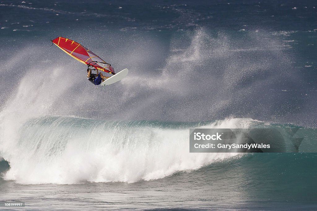 Windsurfer in mid air A windsurfer leaps into the air over a wave on Maui's north shore. Wave - Water Stock Photo